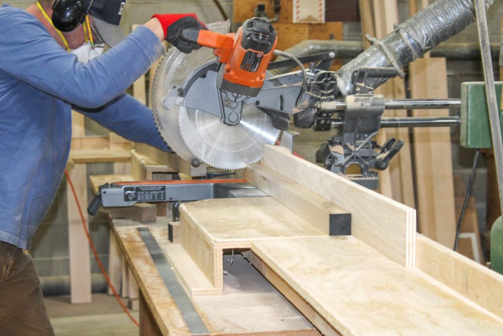 Wood moving through cutter in casegoods manufacturing facility.