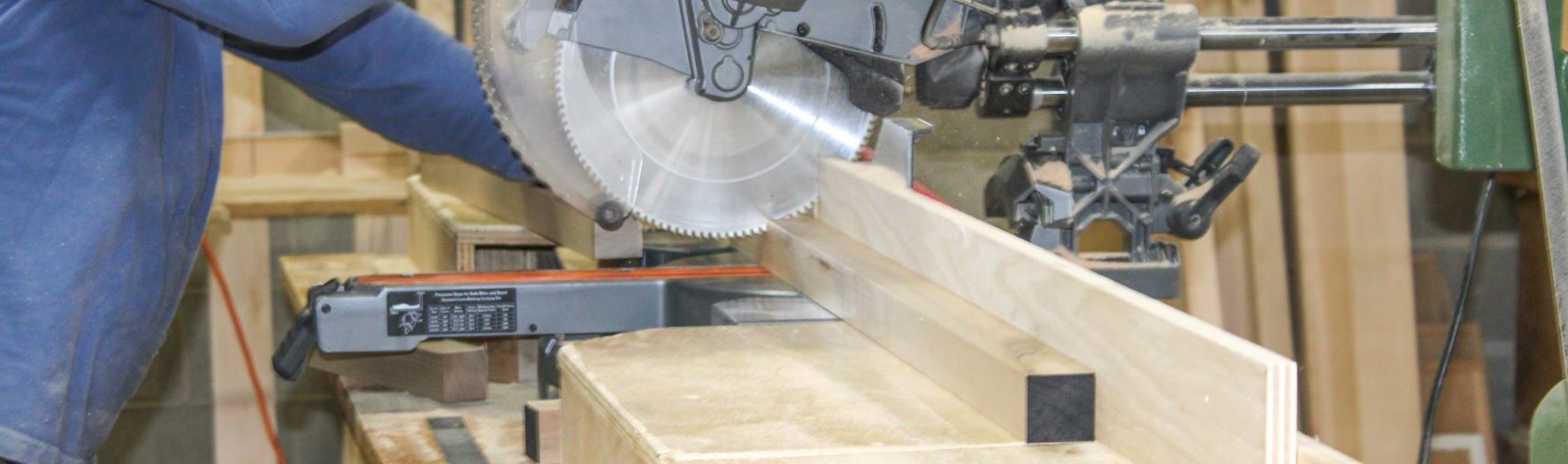 Wood moving through cutter in casegoods manufacturing facility.
